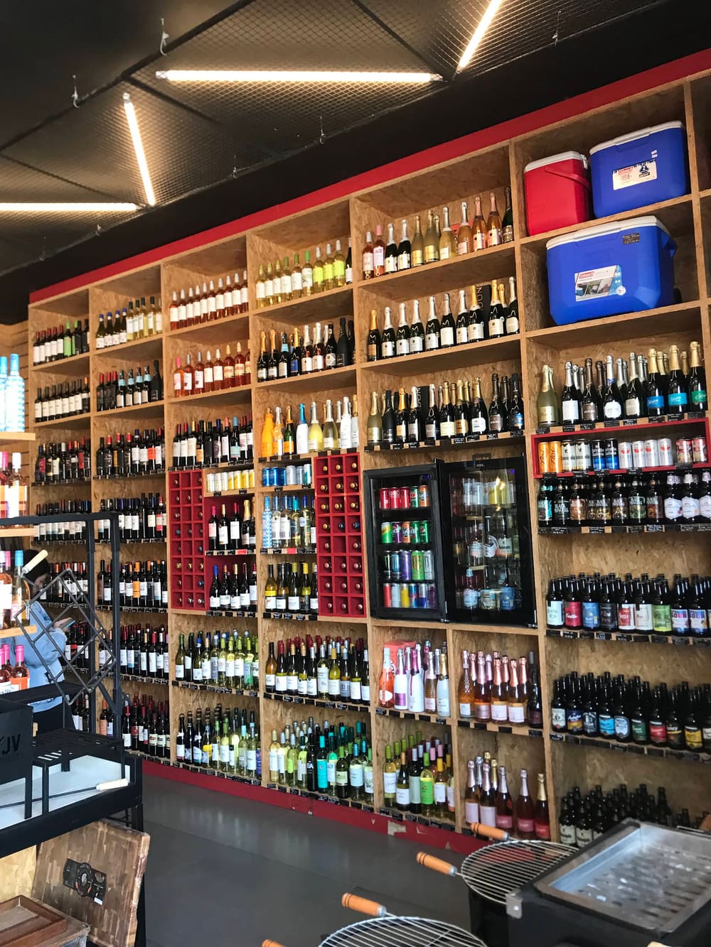 Interior da loja Novo Portinho com prateleiras de bebidas.
